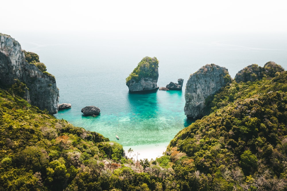 formação rochosa verde e marrom no mar durante o dia