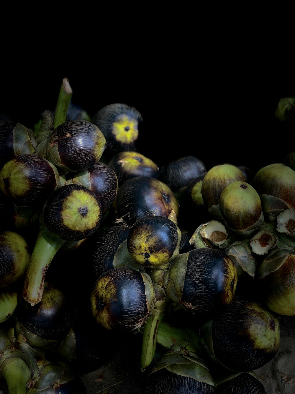 brown and green fruit on black background