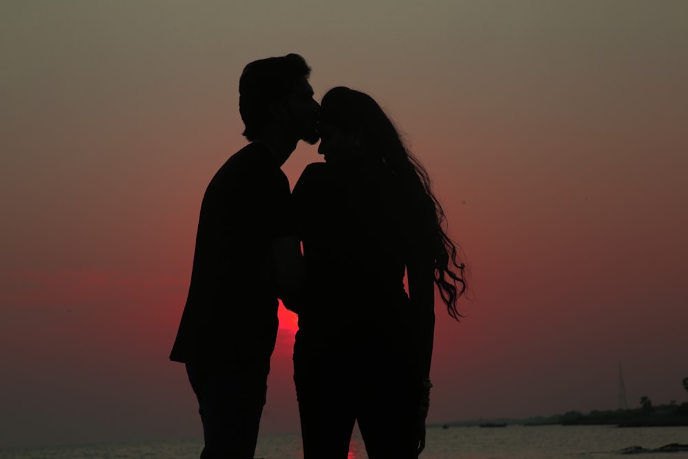 silhouette of couple kissing during sunset