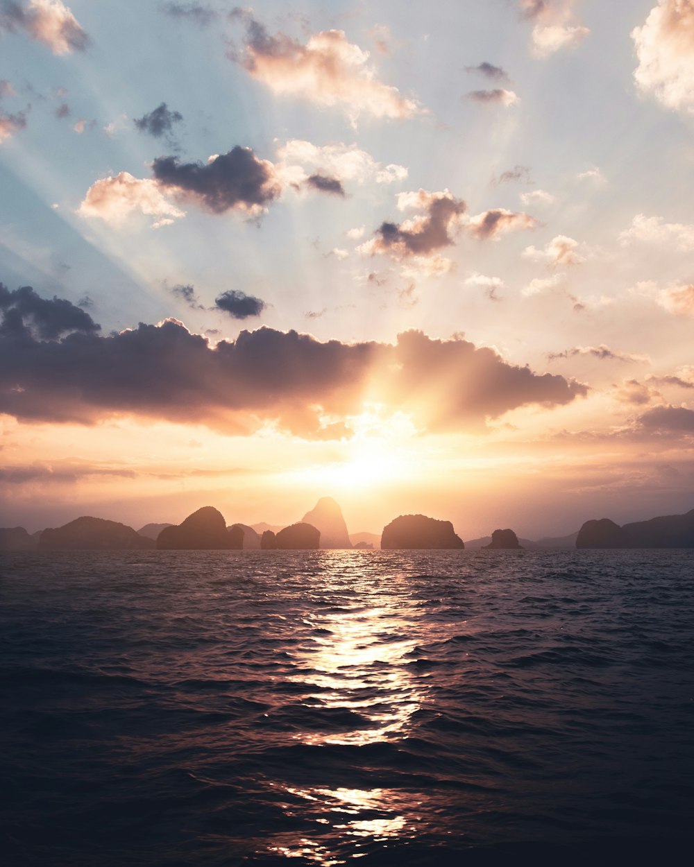 body of water under cloudy sky during sunset