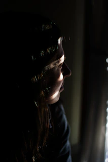 woman in black shirt looking at the window