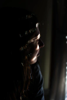 woman in black shirt looking at the window