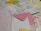 Various stationery items are laid out on a surface, including polka dot wrapping paper, a piece of white lace, a pink envelope, a sheet with floral design, and a yellow ribbon. There are also notepads, one with writing, and a card with a drawn bunny.