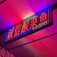 A vibrant neon sign illuminating a modern storefront.