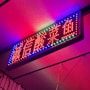 A vibrant neon sign showcasing a client's logo.