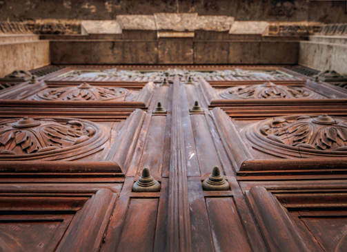 Close-up of intricate Masonic symbols carved in wood on an ancient door.