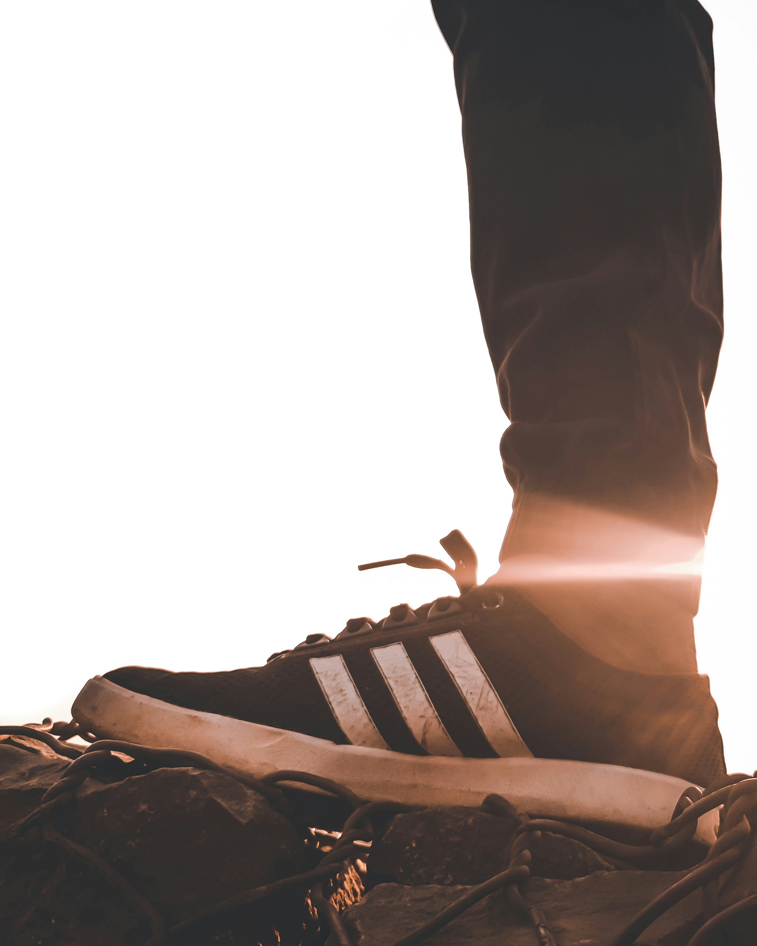 Persona che indossa scarpe da ginnastica adidas bianche e nere