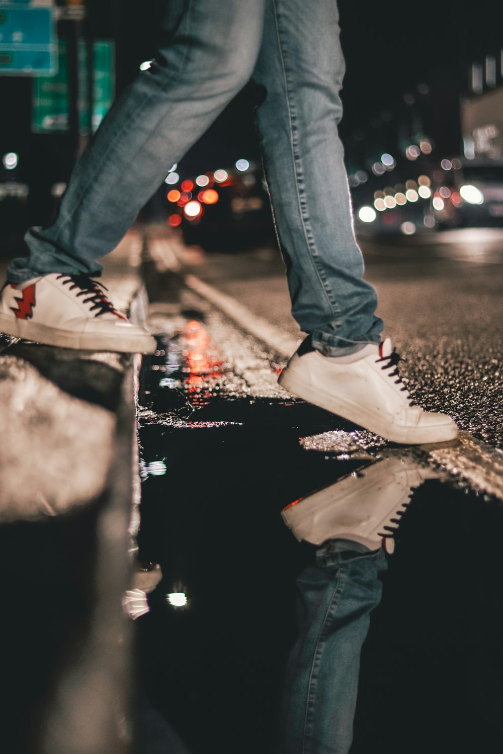 person in blue denim jeans and white sneakers