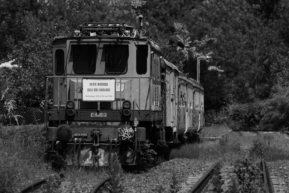 Foto en escala de grises de un tren en las vías del tren