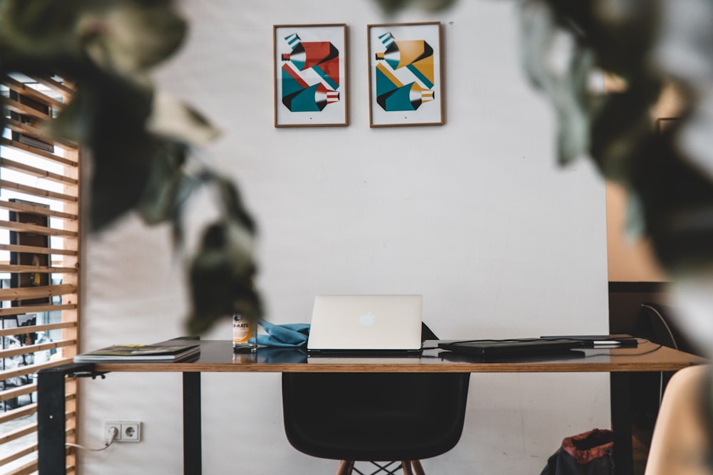 silver macbook on brown wooden table