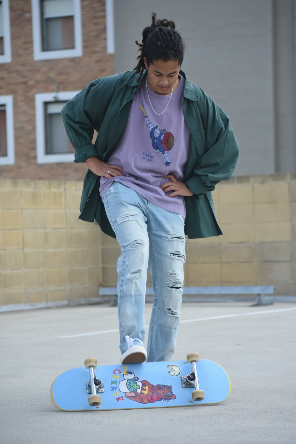 man in green hoodie and blue denim jeans sitting on brown wooden bench