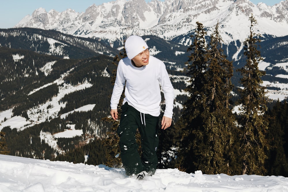 man in white hoodie standing on snow covered ground