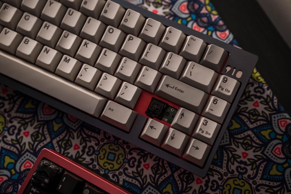 white computer keyboard on black and red textile