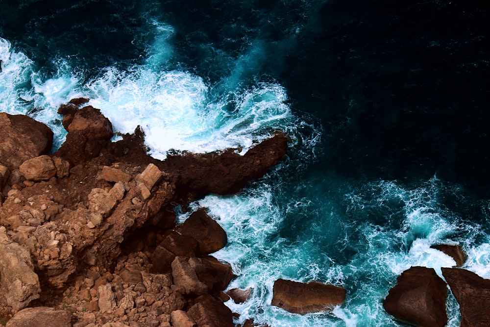 brown rock formation beside body of water during daytime