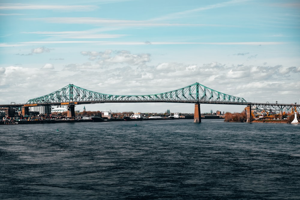 green bridge over the sea under blue sky during daytime