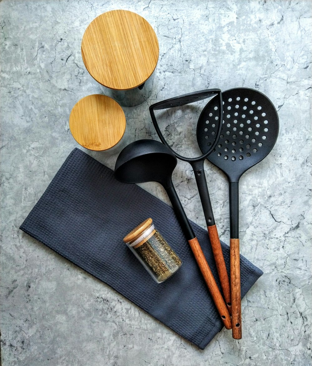 brown wooden spatula beside black handled spatula