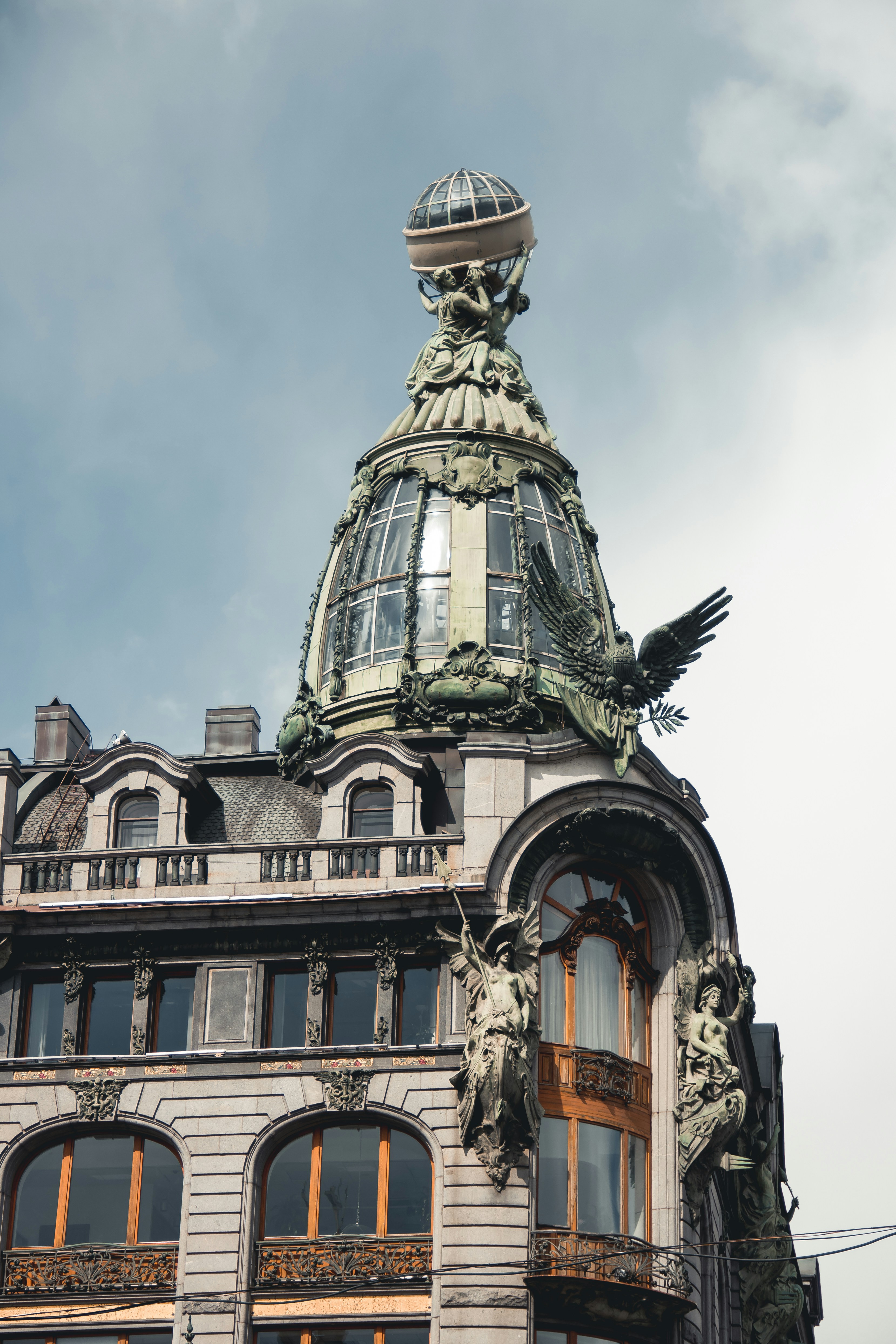 edifício de concreto verde e marrom sob nuvens brancas durante o dia
