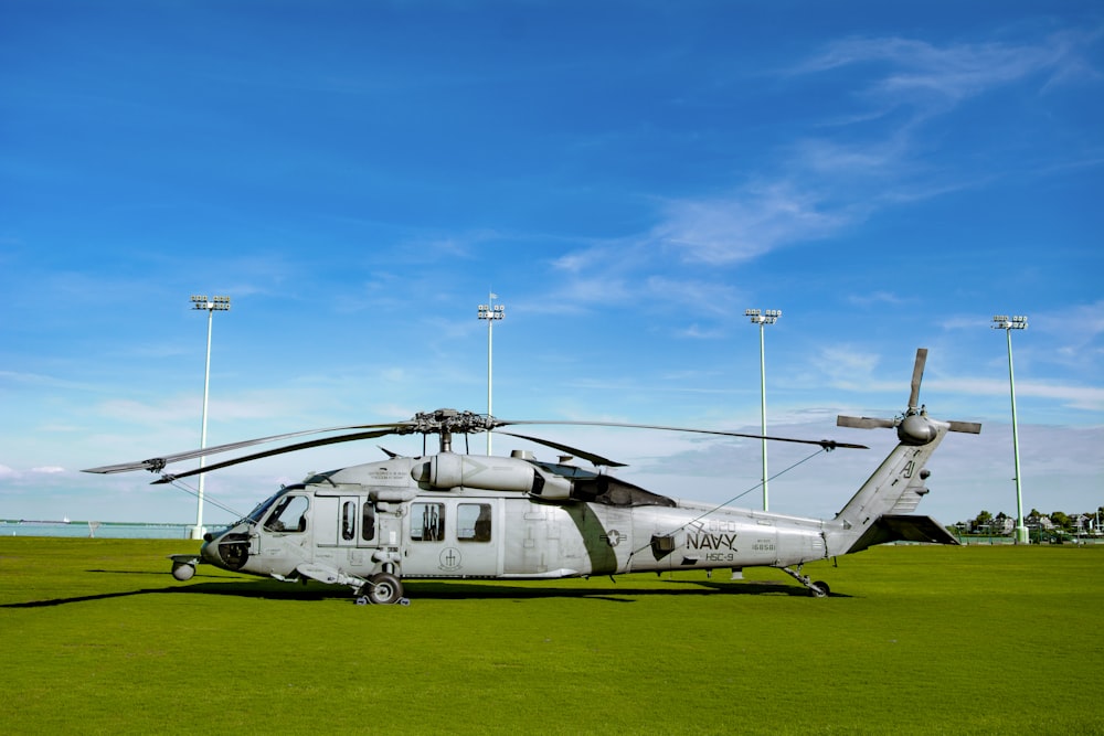 white and blue airplane on green grass field under blue sky during daytime