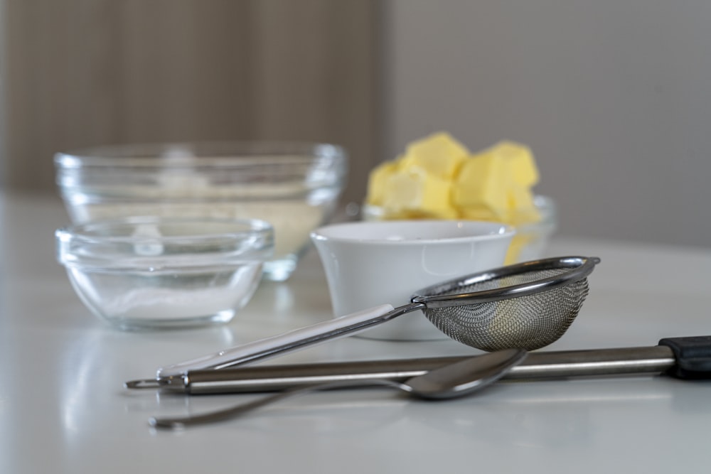 silver and black kitchen utensil on white ceramic bowl