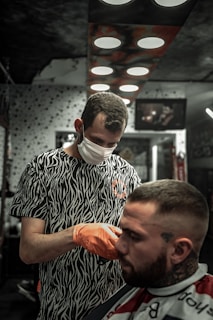man in black and white crew neck shirt holding orange fruit