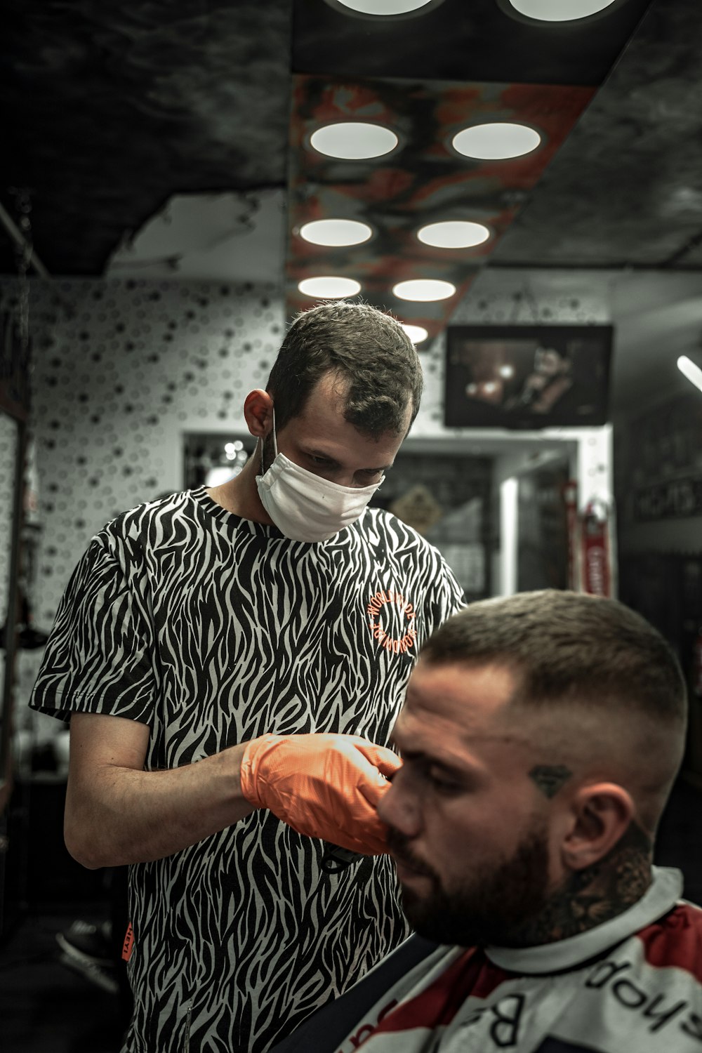 man in black and white crew neck shirt holding orange fruit