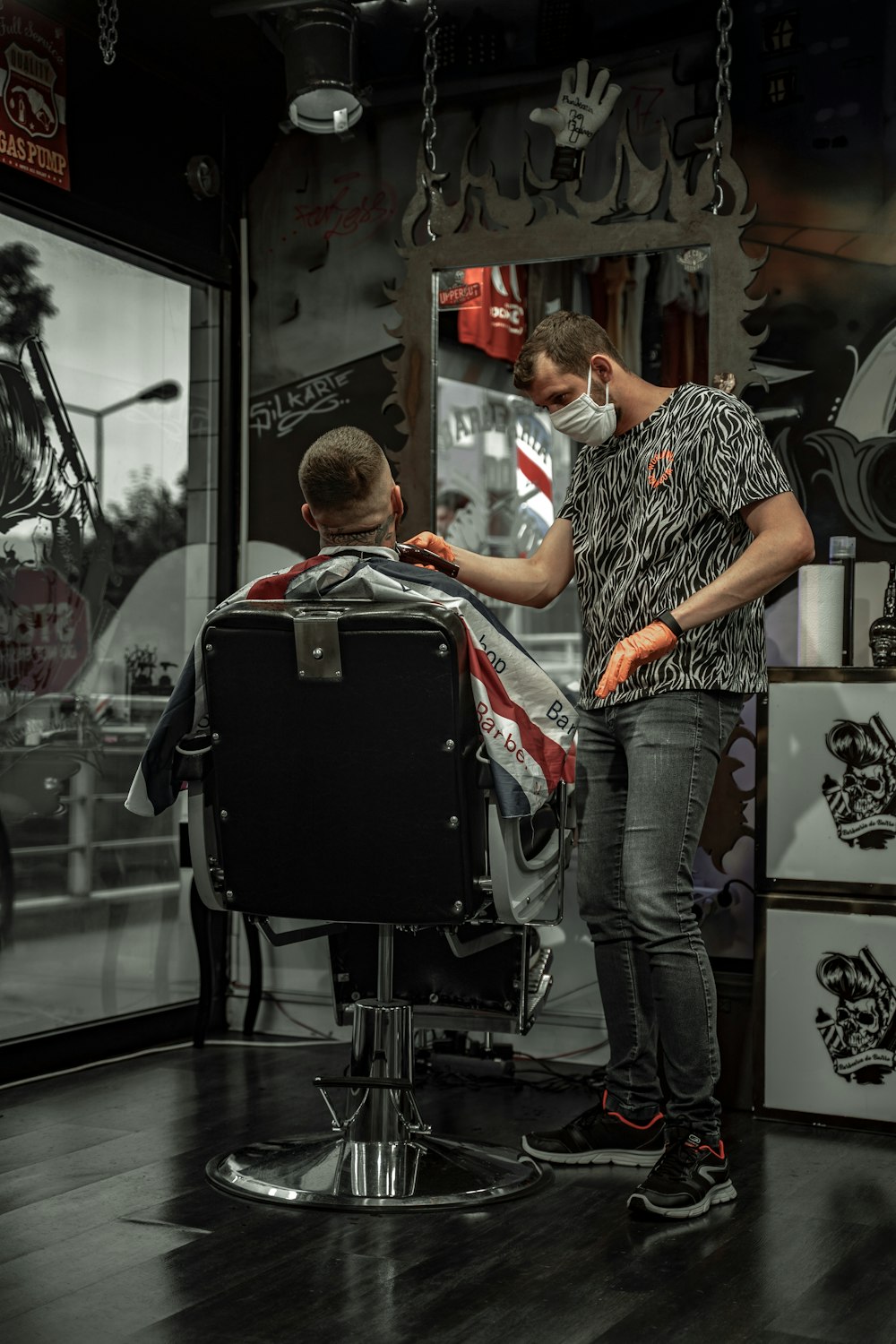 man in black and white shirt sitting on barber chair