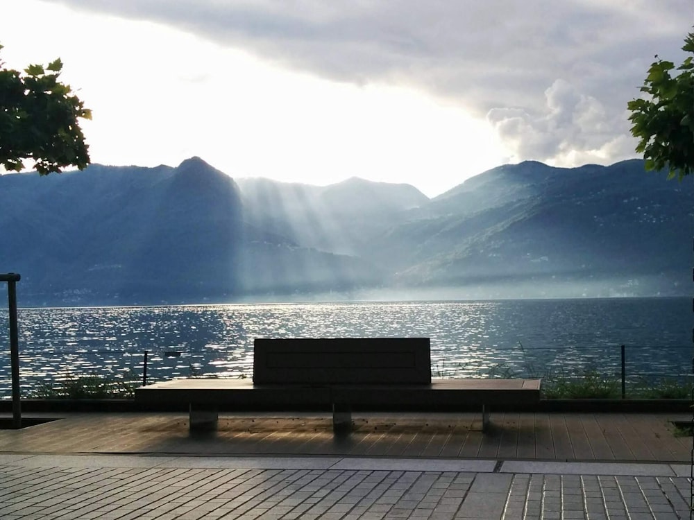 brown wooden bench near body of water during daytime