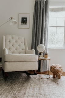 white sofa chair near white window curtain