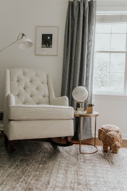white sofa chair near white window curtain