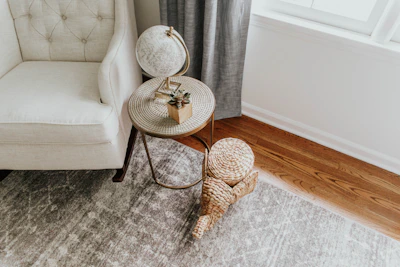 A living room corner featuring a soft rug, a small side table, and a comfy armchair.
