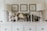 A chic dresser display featuring two modern lamps with patterned bases, several decorative ceramics with a textured design, framed minimalist art prints on the wall, various potted plants, and a selection of books and home décor items arranged neatly.