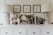 A chic dresser display featuring two modern lamps with patterned bases, several decorative ceramics with a textured design, framed minimalist art prints on the wall, various potted plants, and a selection of books and home décor items arranged neatly.