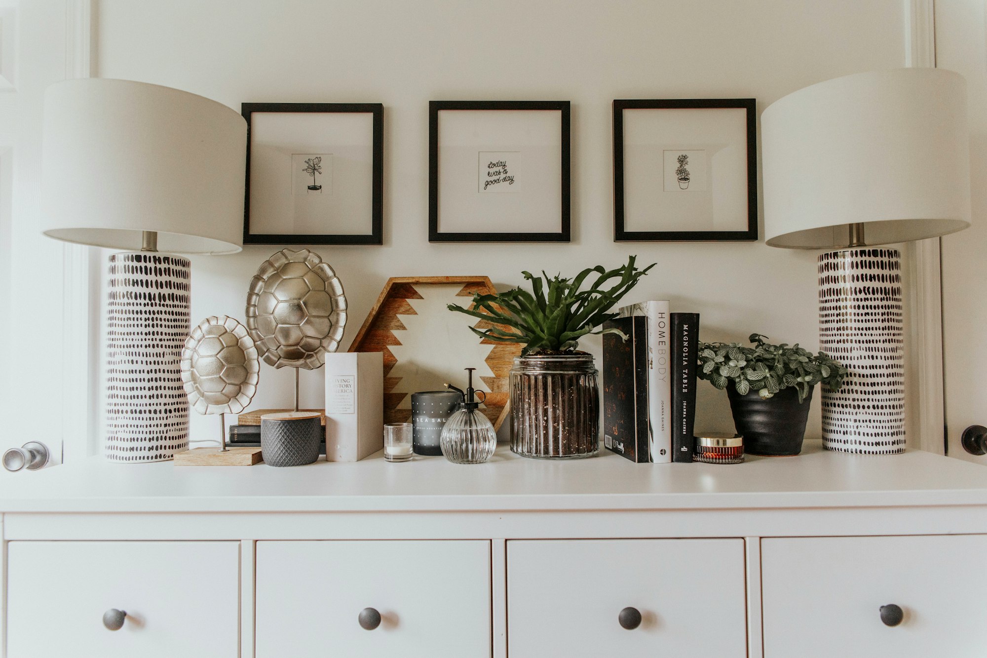 Display ornaments on top of a white wooden cabinet.