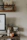 Close-up of a detailed Asian print hanging above a modern desk setup.