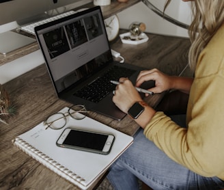 person in blue denim jeans using macbook pro