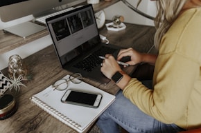 person in blue denim jeans using macbook pro
