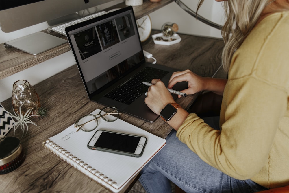 person in blue denim jeans using macbook pro