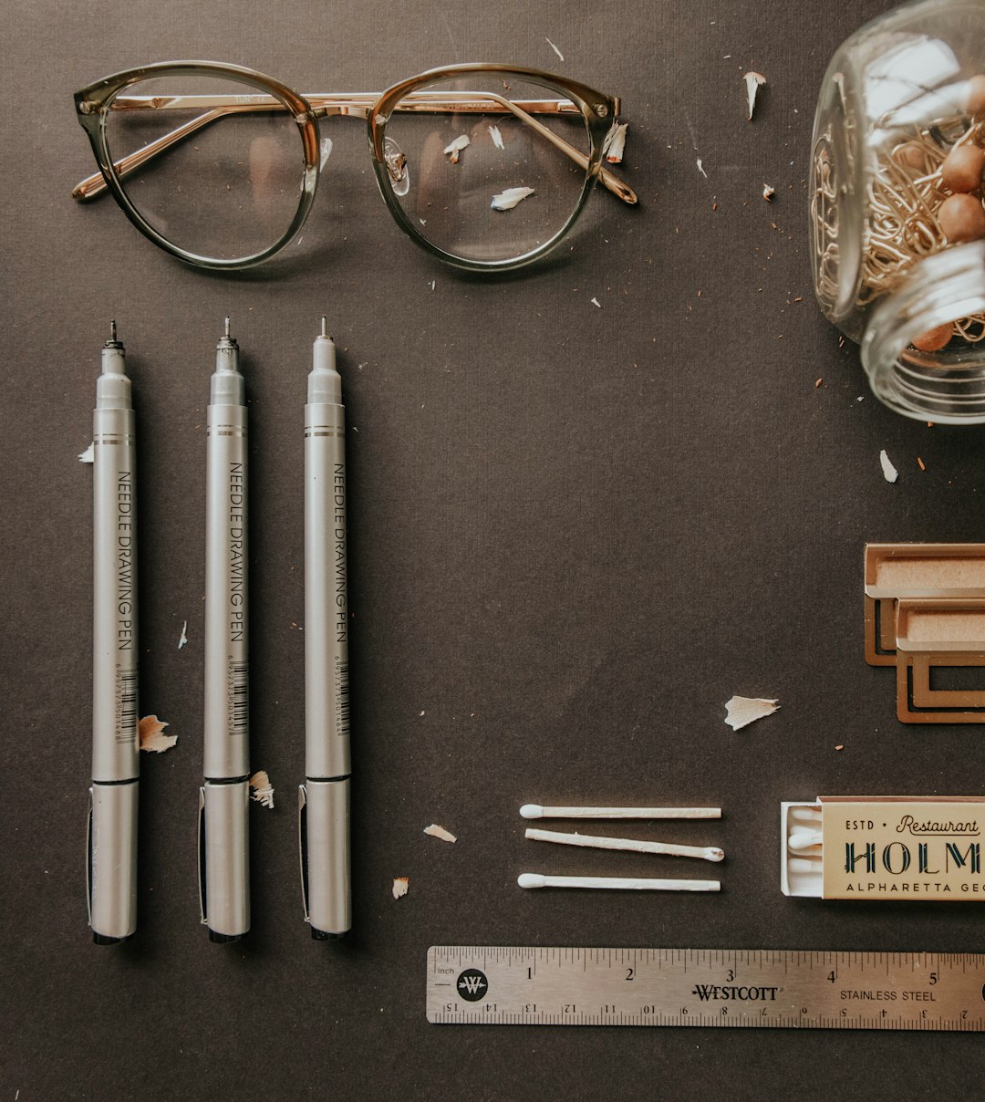 black framed eyeglasses beside white pen and brown framed eyeglasses