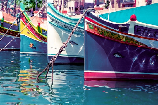 red and brown boat on water in Marsaxlokk Malta