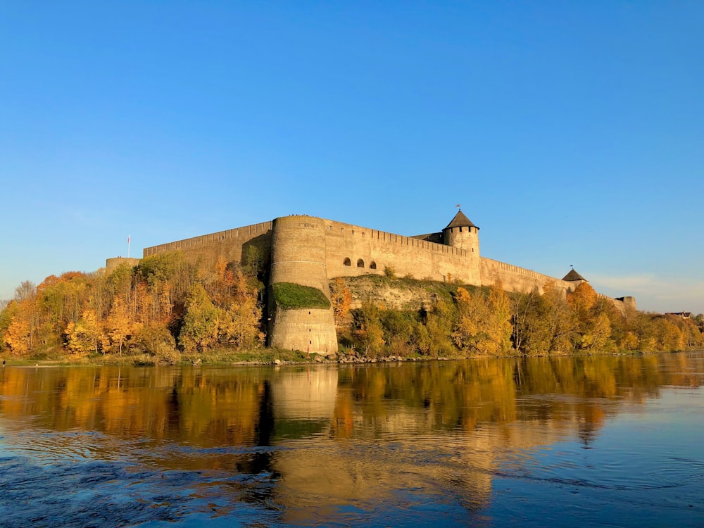 brown concrete building on top of hill by the sea under blue sky during daytime