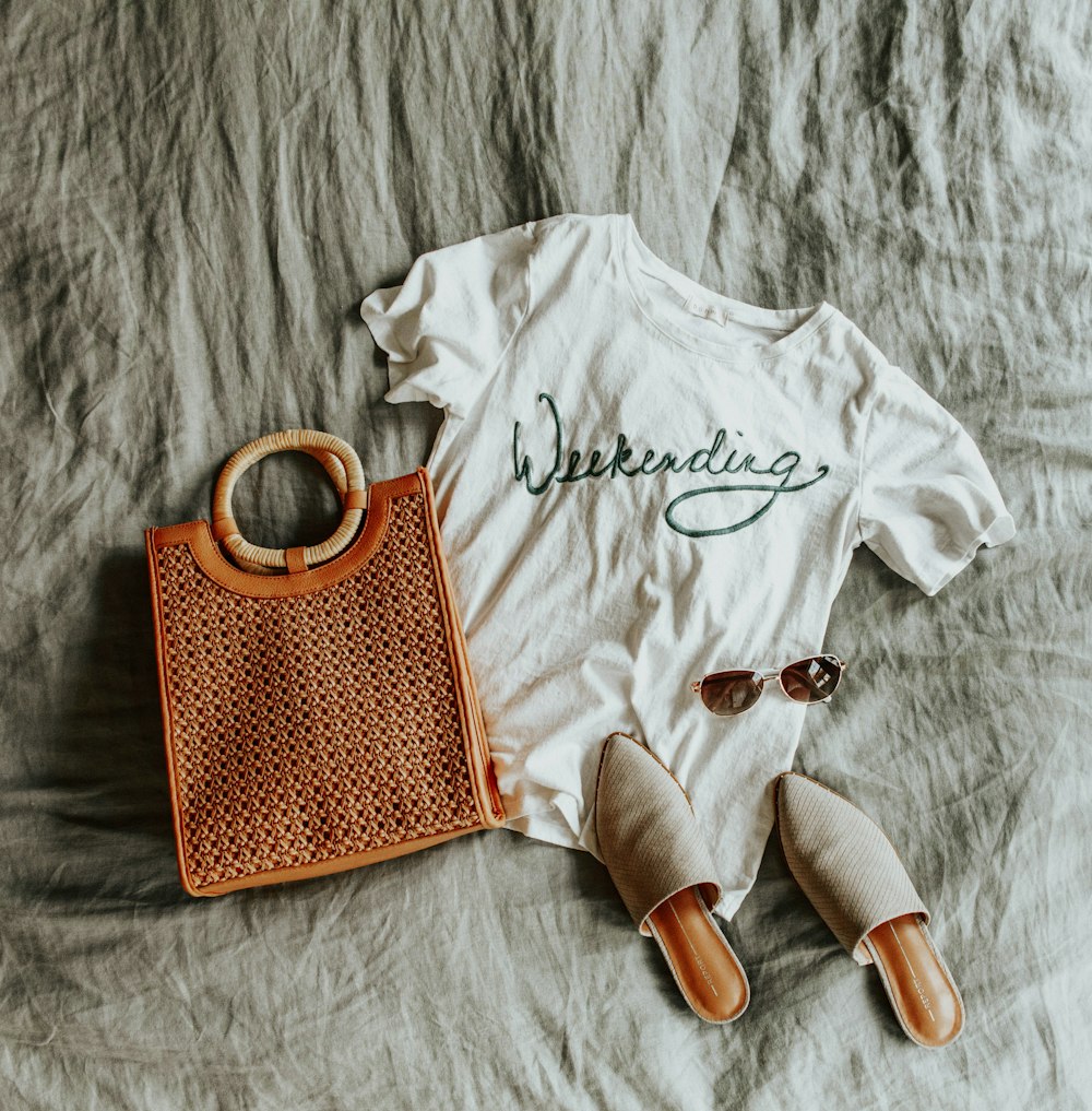 white and red polka dot crew neck shirt beside white crew neck shirt and brown leather