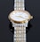 A close-up view of a luxury wristwatch featuring a gold and silver metal band. The watch has a round face with a white dial, golden hour markers, and hands. The brand name and model 'Tissot 1853 Powermatic 80' are visible on the dial.