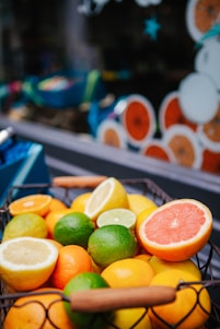 A vibrant basket of freshly picked Calabrian citrus fruits on a rustic wooden table.