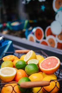 A bunch of vibrant citrus fruits including oranges and lemons on a woven basket.
