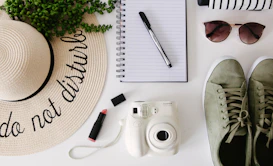 white and silver point and shoot camera beside black pen and black pen
