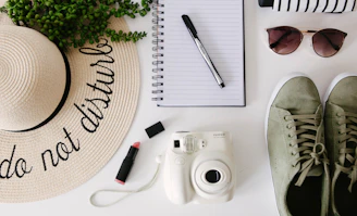 white and silver point and shoot camera beside black pen and black pen