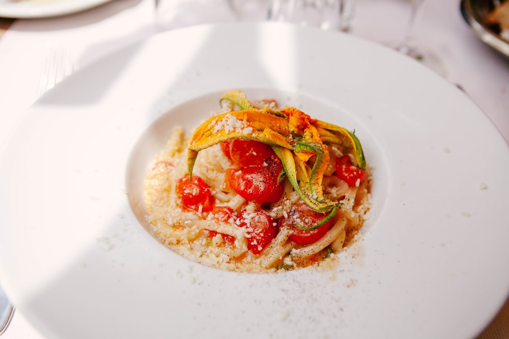 Brot mit Tomaten und grünem Blattgemüse auf weißem Keramikteller