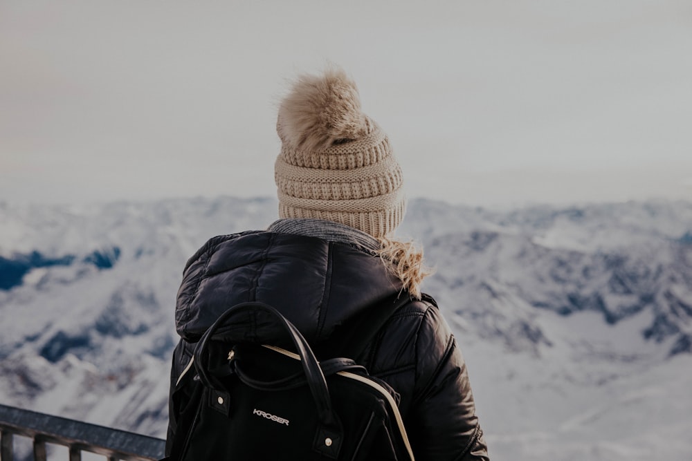 person in black jacket and brown knit cap