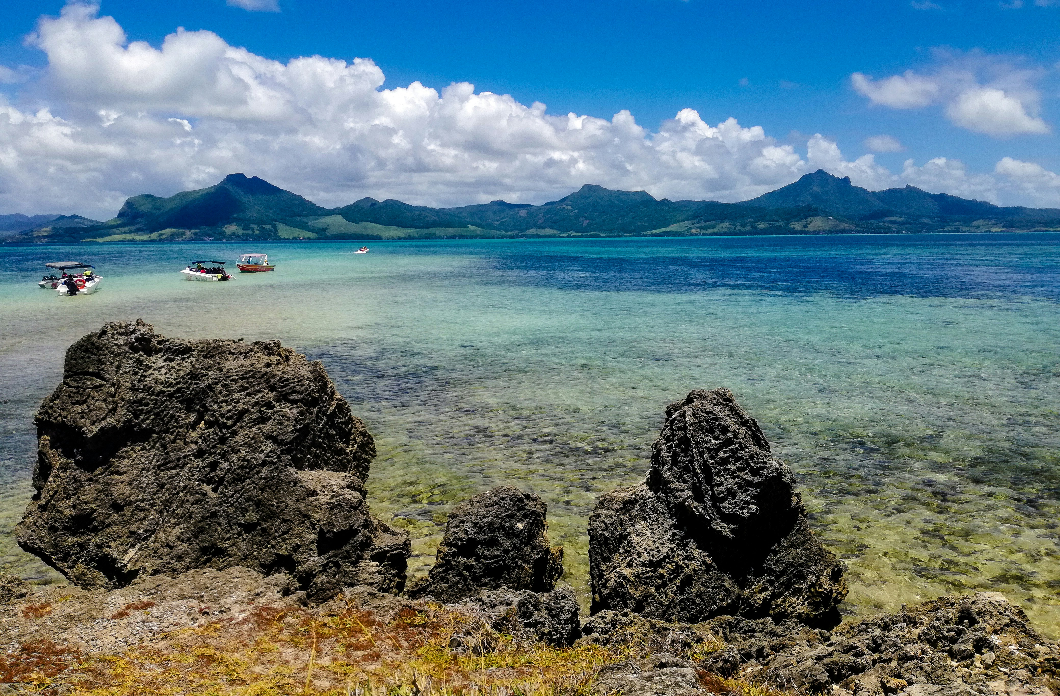 body of water near mountain under blue sky during daytime