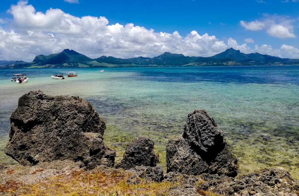 Cuerpo de agua cerca de la montaña bajo el cielo azul durante el día